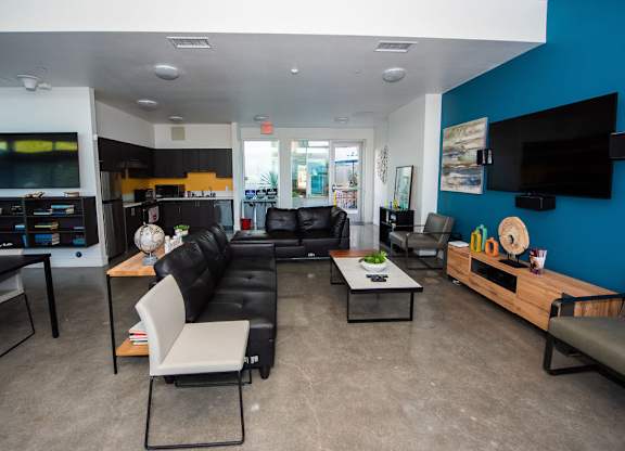 A living room with a black couch and a white chair.