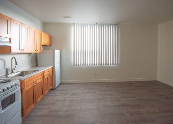 A kitchen with wooden cabinets and a white refrigerator.