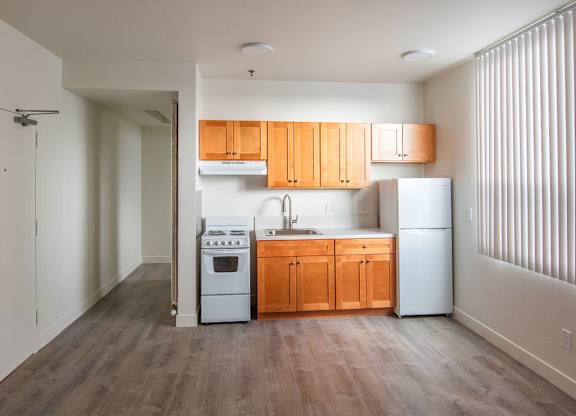 A kitchen with wooden cabinets and a white refrigerator.