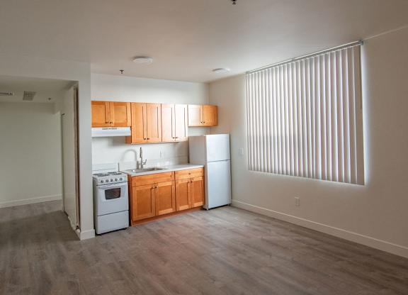 A kitchen with wooden floors and white appliances.