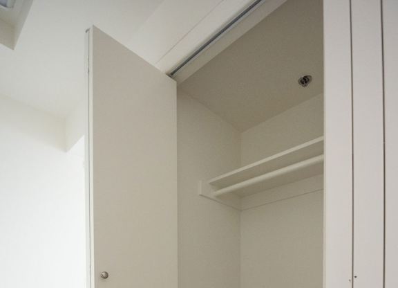A white door is open to a room with a wooden floor.