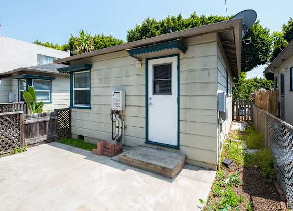 A small house with a white door and a green window.