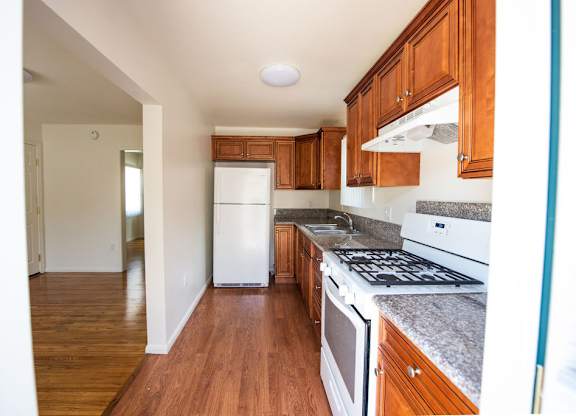 A kitchen with wooden cabinets and a white fridge.