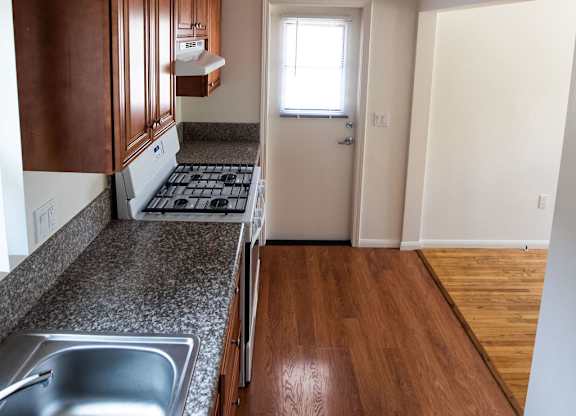 A kitchen with wooden cabinets and a white fridge.