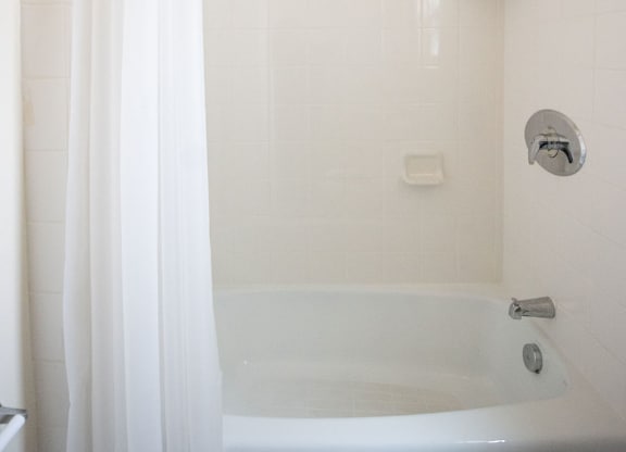 A white bathroom with a tub and shower.