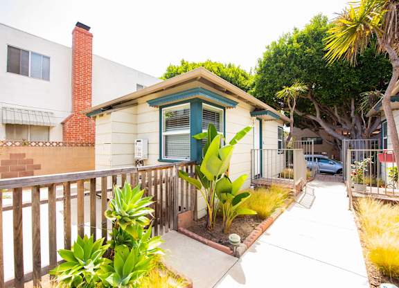 A small house with a green door and a brown fence.