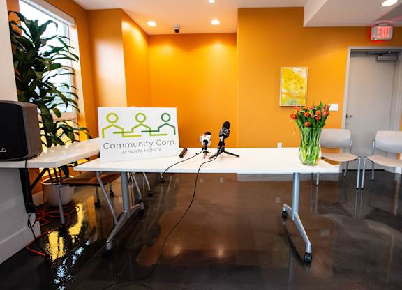 A conference room with a sign that says Community Corp of Santa Monica.