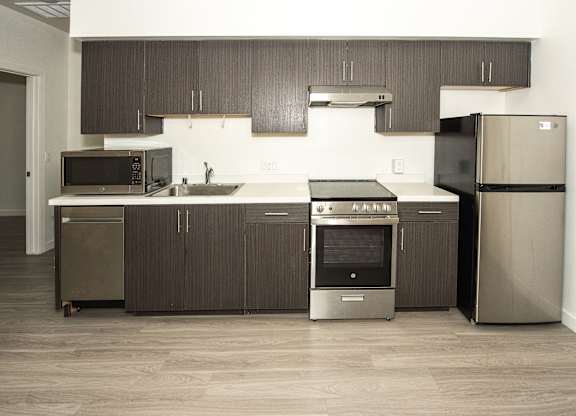 Sample Unit: Kitchen and Appliances including refrigerator, microwave, stove, and cabinets