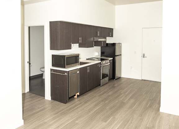 A kitchen with wooden floors and white walls.