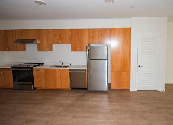 Sample 2 Bedroom Apartment: A kitchen with wooden cabinets and a stainless steel refrigerator.