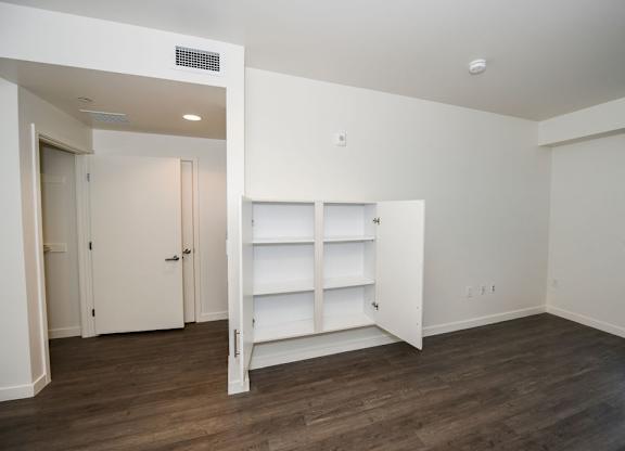 A room with a white wall and a wooden floor.
