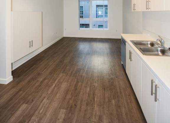 A kitchen with wooden floors and white cabinets.