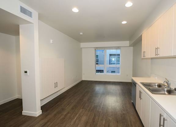 A kitchen with white cabinets and a window.