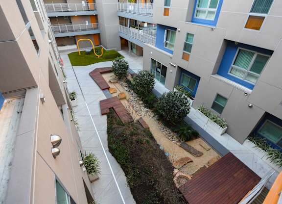A modern apartment complex with a playground in the courtyard.