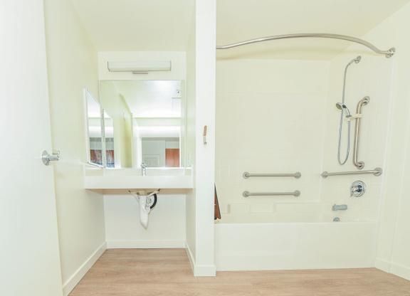 Sample 2 Bed Accessible Unit: A bathroom with a white sink and a white bathtub.