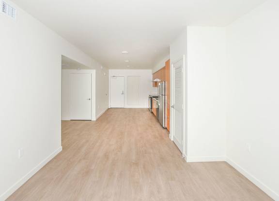 Sample 2 Bed Unit: A long hallway with white walls and wood flooring.