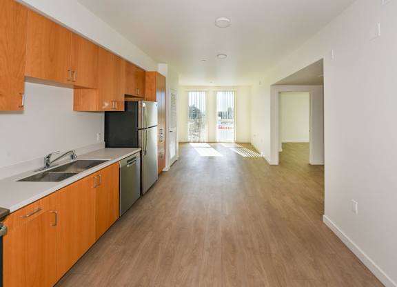Sample 2 Bed Unit: A kitchen with wooden cabinets and a black fridge.