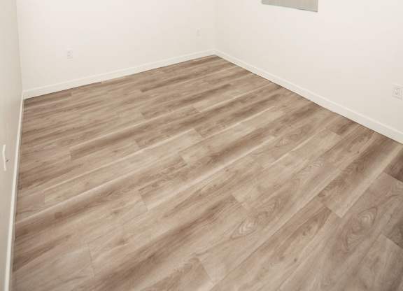 A room with a window and wooden flooring.