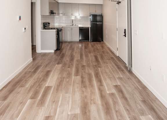 A long hallway with a kitchen visible in the distance.