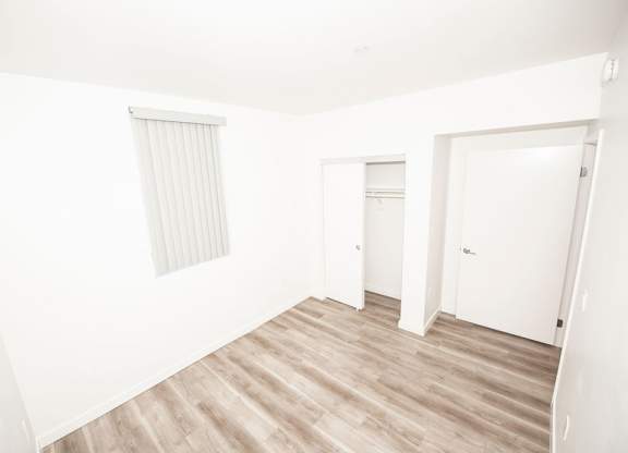 A room with a window and wooden flooring.