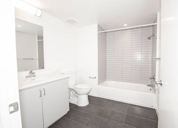 A white bathroom with a toilet, sink, and bathtub.