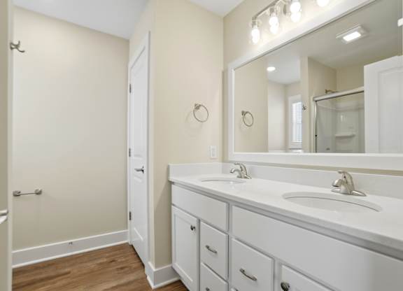 A bathroom with a white sink and a mirror above it.