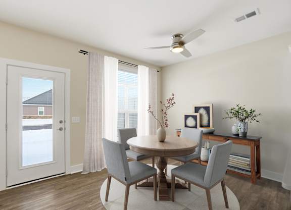 A dining room with a table and chairs.