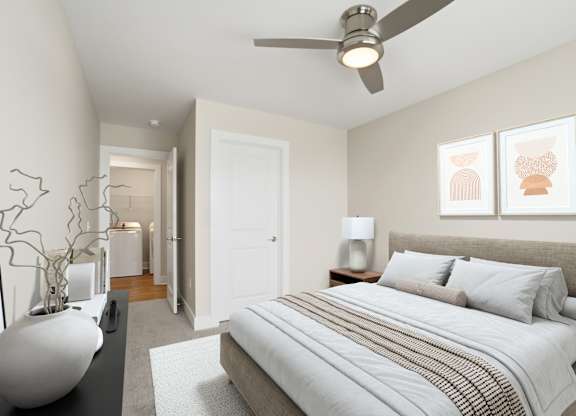 A bedroom with a large bed and a ceiling fan.