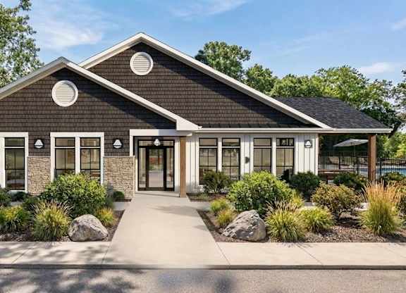 A modern house with a black roof and white trim.