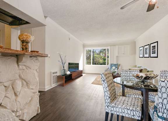 Dining area with ceiling fan, wood style floors throughout, breakfast bar
