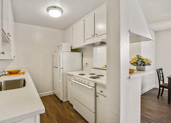 Kitchen with refrigerator, microwave, electric range, white quartz countertops, white kitchen cabinets