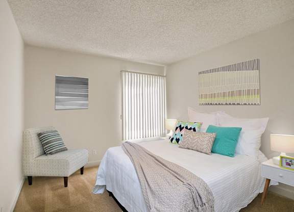 Bedroom with carpet flooring, vertical blinds. Not all features are available in every apartment.