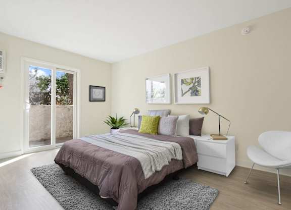 Bedroom with wood style floors, private balcony or patio with sliding glass door on the left