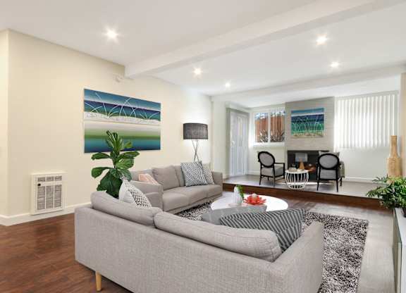 Living room with cozy fireplace, recessed lighting, wood style flooring. Not all features are available in every apartment.