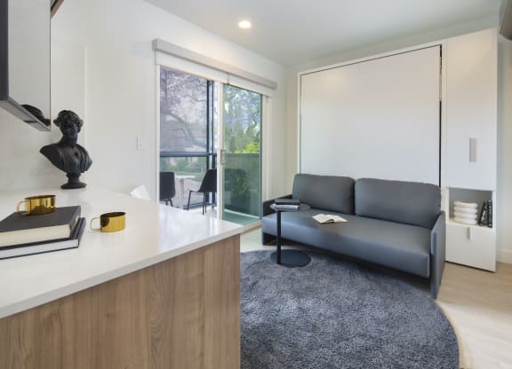 a living room with a gray couch and a white counter top