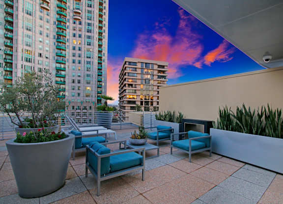 A patio with a couch and a table with a potted plant on it.at Wilshire Margot, Los Angeles, 90024