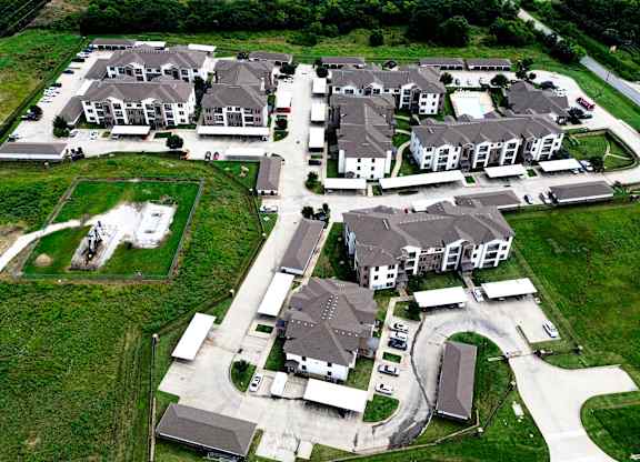 A bird's eye view of a housing development with multiple houses and a central courtyard.