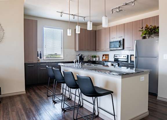 a kitchen with a large center island with a breakfast bar