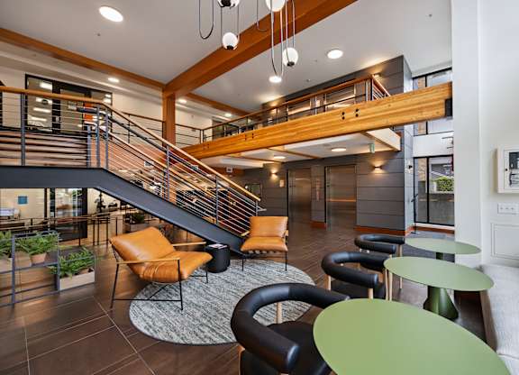 Modern lobby with staircase and seating area at The Lyric Apartments, Seattle, WA 98102