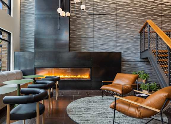 Contemporary lounge with linear fireplace and staircase at The Lyric Apartments, Seattle, Washington