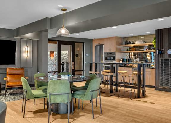 Community dining space with modern kitchen and bar seating at The Lyric Apartments, Washington