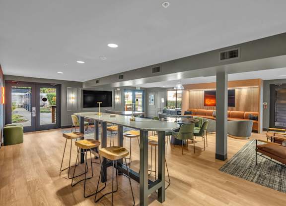 Clubroom with high top tables and lounge areas at The Lyric Apartments, Seattle, WA