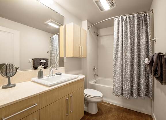 Bathroom with soaking tub and geometric shower curtain at The Lyric Apartments, Seattle, WA 98102