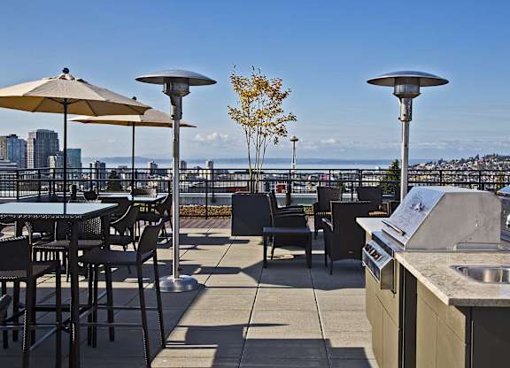 Rooftop terrace with outdoor kitchen and patio heaters at The Lyric Apartments, Seattle, 98102