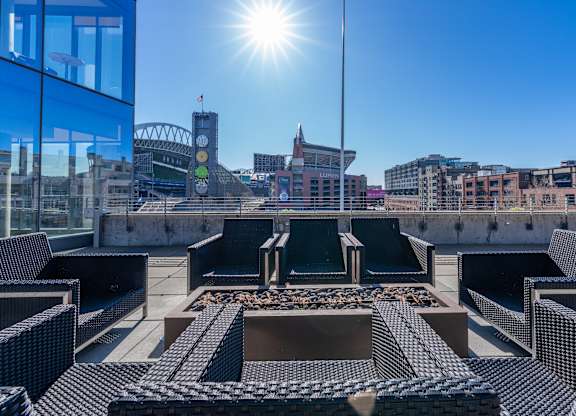 views of the city skyline from the roof of a building with lounge chairs