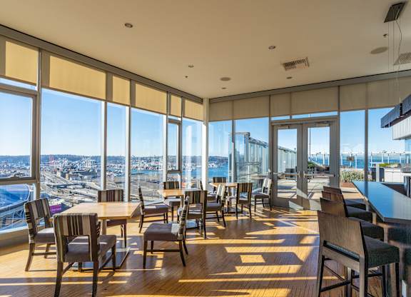 a restaurant with tables and chairs and a view of the city