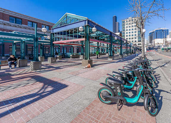 a row of bikes parked on a sidewalk in front of a building