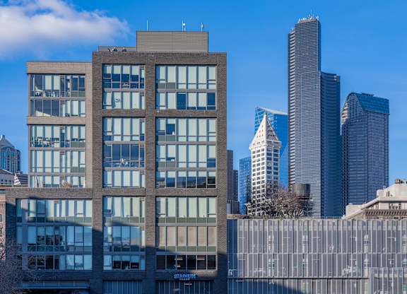 a large brick building with skyscrapers in the background