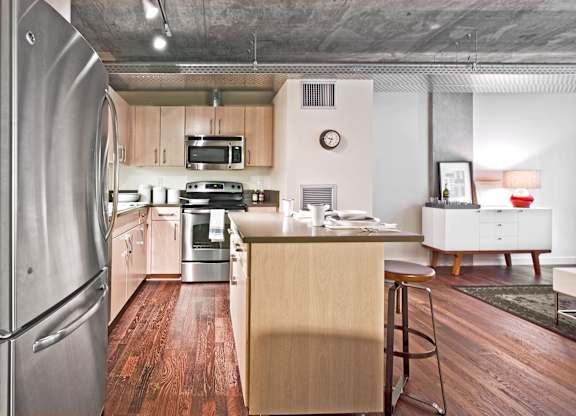a kitchen with a island and a stainless steel refrigerator