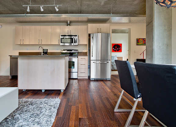a kitchen with white cabinets and a stainless steel refrigerator